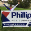 Dean supporter standing with her Phillips for Congress yard sign