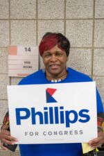 A supporter holds a Phillips sign on caucus night. A supporter holds a Phillips sign on caucus night.